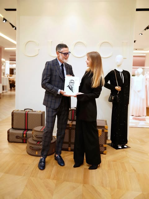 A guest receiving his portrait from the artist at a Gucci event